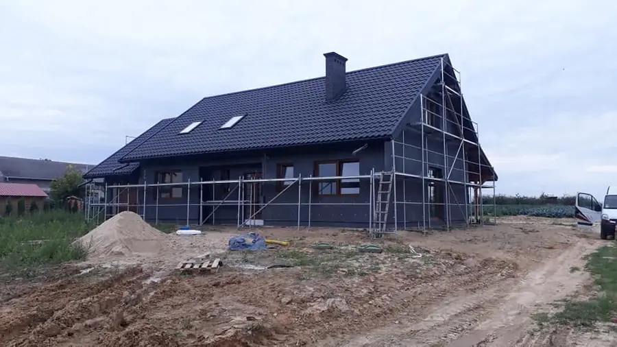 Dom w trakcie ocieplania: ściany pokryte płytami ocieplenia, wokół rusztowania